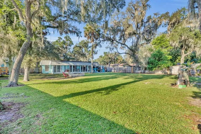 a view of swimming pool with large trees and a big yard