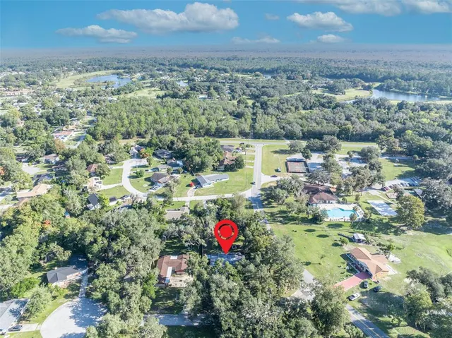 an aerial view of residential houses with outdoor space and trees