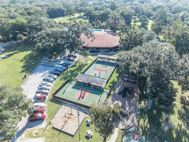 an aerial view of a house swimming pool and red chairs