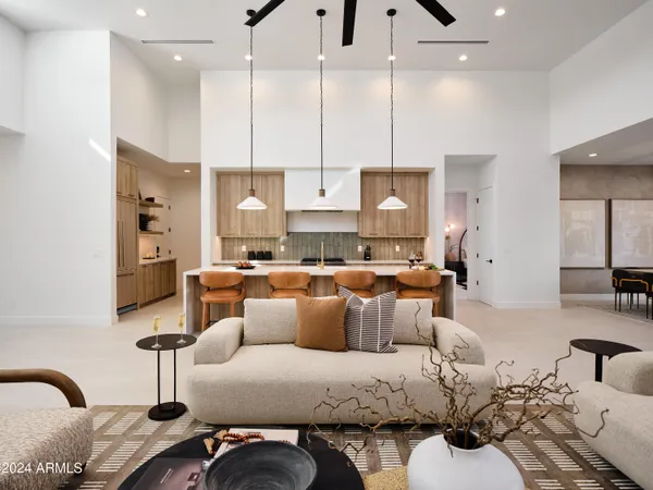 a living room with furniture kitchen view and a chandelier