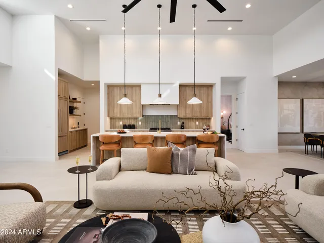 a living room with furniture kitchen view and a chandelier