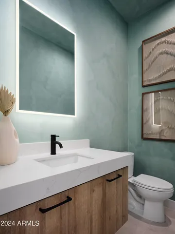 a bathroom with a sink a toilet and mirror