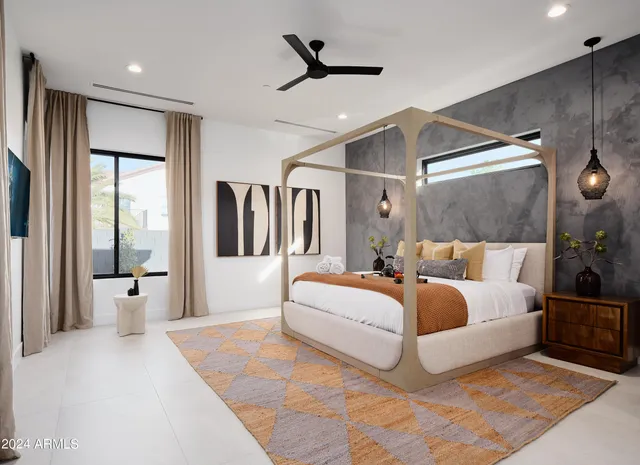 a spacious bedroom with a large bed and a chandelier