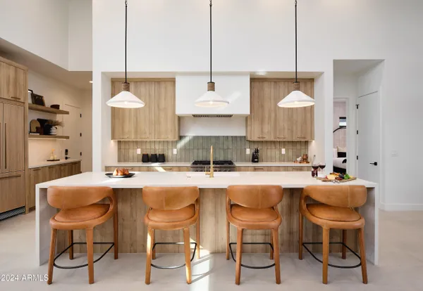 a kitchen with a dining table chairs and cabinets