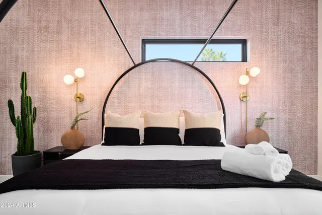 a bedroom with a bed lamp and a potted plant