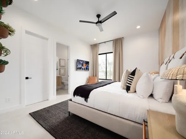 a bedroom with a large bed and a chandelier