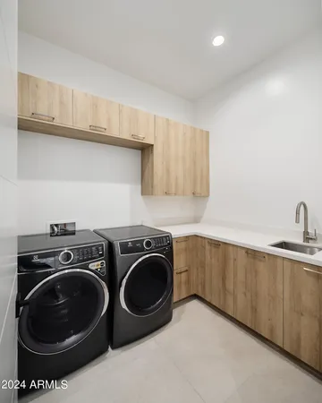 a utility room with sink dryer and washer