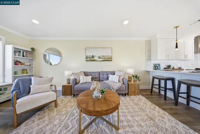 a view of a hallway with wooden floor and a living room