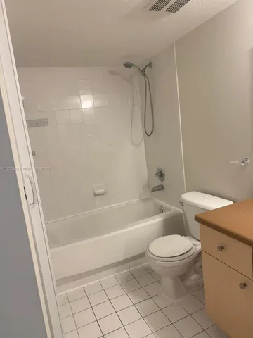a bathroom with a granite countertop toilet a sink and a bathtub