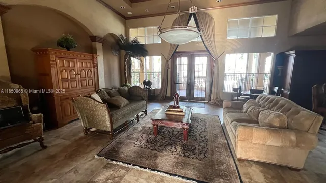 a living room with furniture a chandelier and a large window