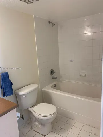 a white toilet and tub sitting next to a bathroom sink