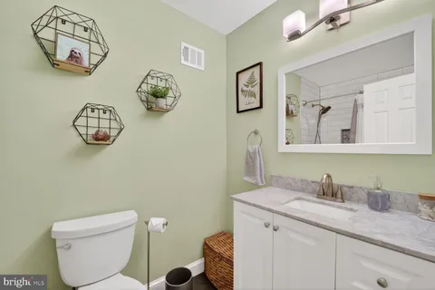 a bathroom with a toilet a sink and mirror