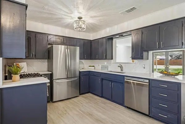 a kitchen with a refrigerator sink and wooden cabinets