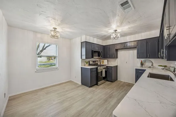 a kitchen with refrigerator a microwave and cabinets