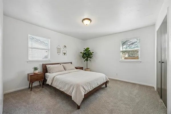a bedroom with a bed and a potted plant
