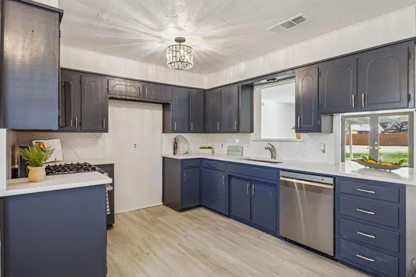 a kitchen with a sink appliances and cabinets