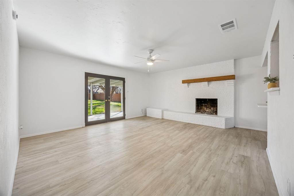 312 East Hampton Road Crowley, TX 76036 - Photo 8 of 22 an empty room with windows and fireplace