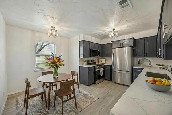 a kitchen with refrigerator and dining table