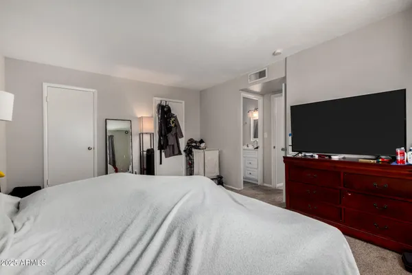 a bedroom with a bed and a flat screen tv