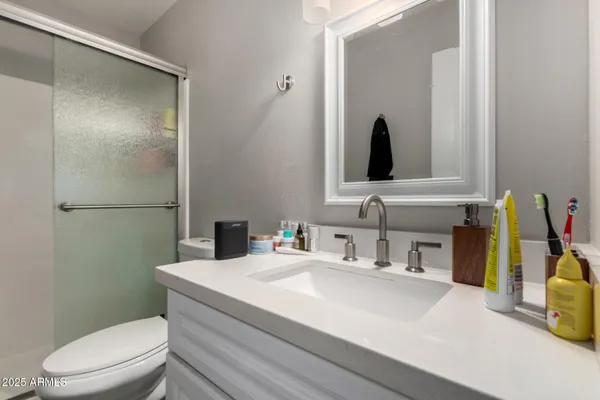 a bathroom with a toilet sink vanity and mirror