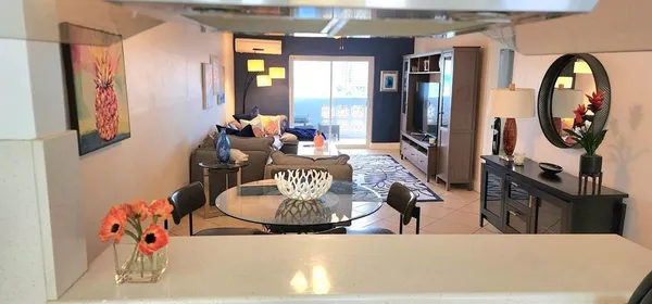 a living room with furniture a chandelier and a large mirror