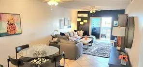 a living room with furniture kitchen view and a chandelier