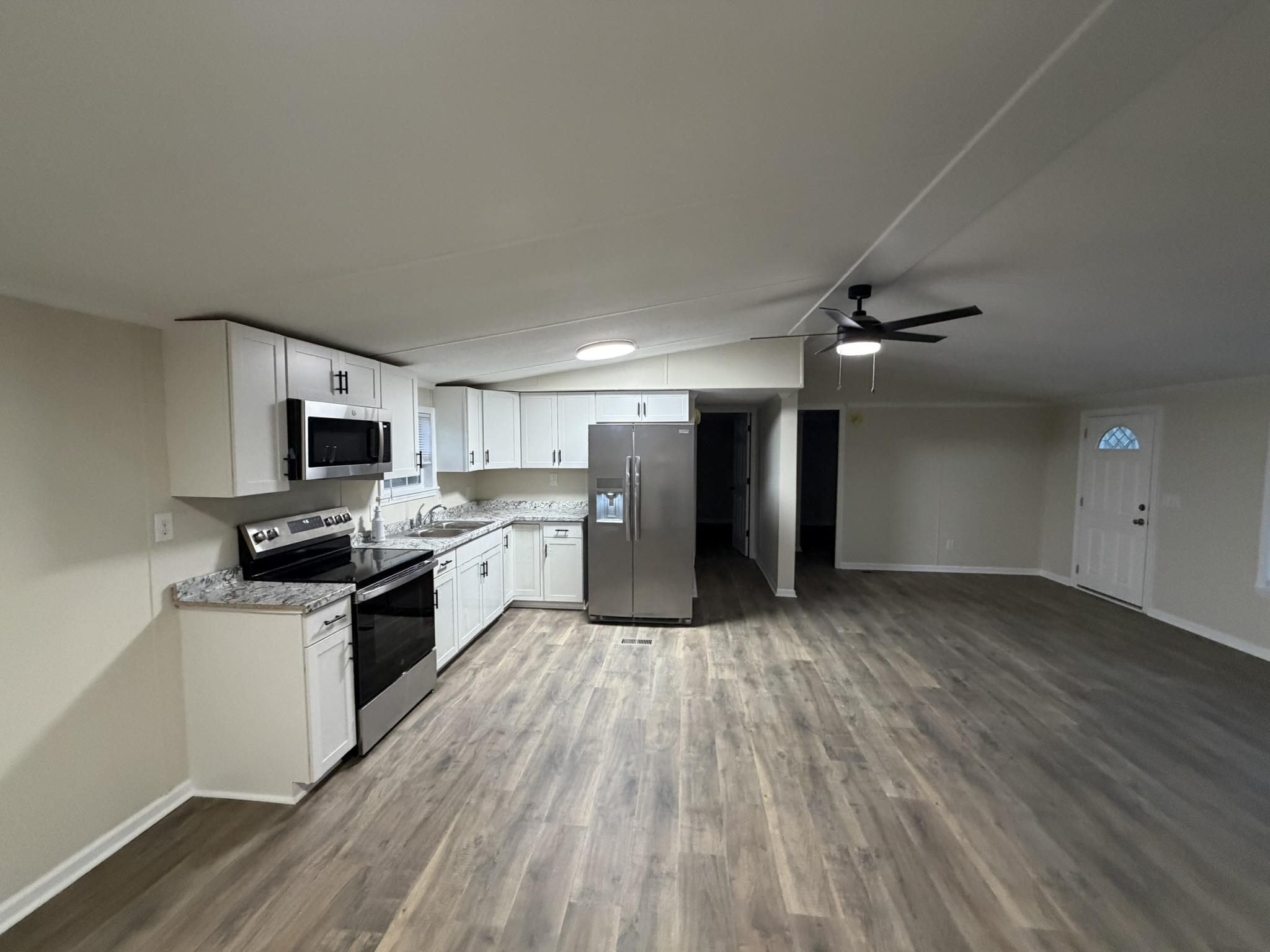 118 Nell Court Loris, SC 29569 - Photo 13 of 23 Kitchen featuring appliances with stainless steel finishes, white cabinets, lofted ceiling, ceiling fan, and light wood-type flooring