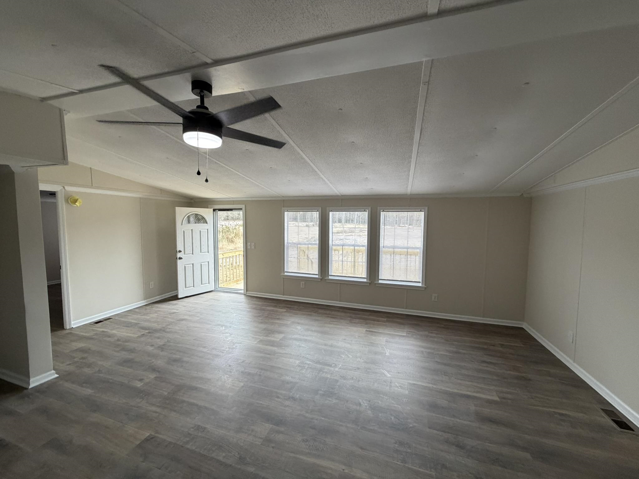 118 Nell Court Loris, SC 29569 - Photo 4 of 23 Unfurnished room with vaulted ceiling, dark wood-style flooring, and ceiling fan