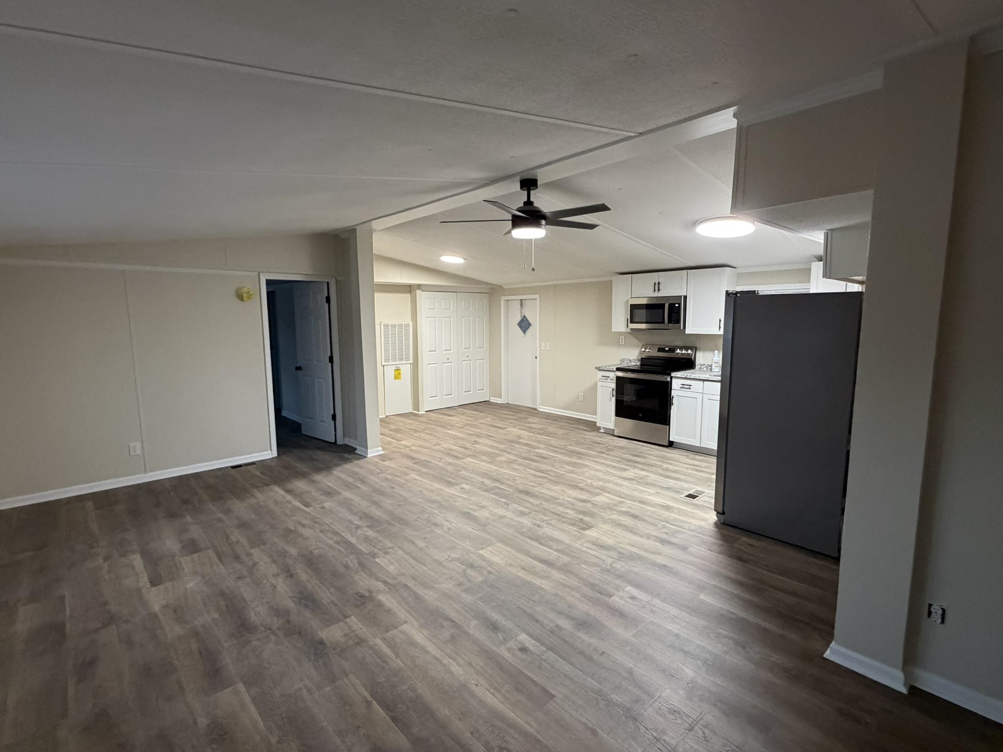 118 Nell Court Loris, SC 29569 - Photo 5 of 23 Kitchen with appliances with stainless steel finishes, white cabinetry, a ceiling fan, light countertops, and light wood finished floors
