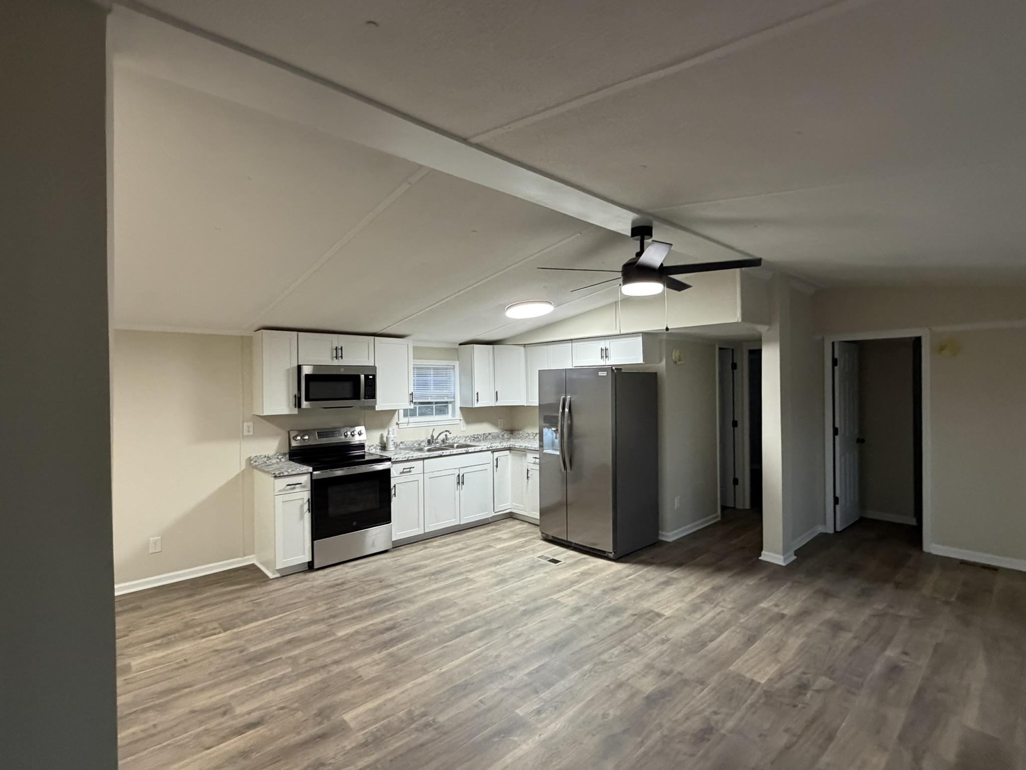 118 Nell Court Loris, SC 29569 - Photo 6 of 23 Kitchen featuring appliances with stainless steel finishes, white cabinets, light wood-type flooring, and a ceiling fan