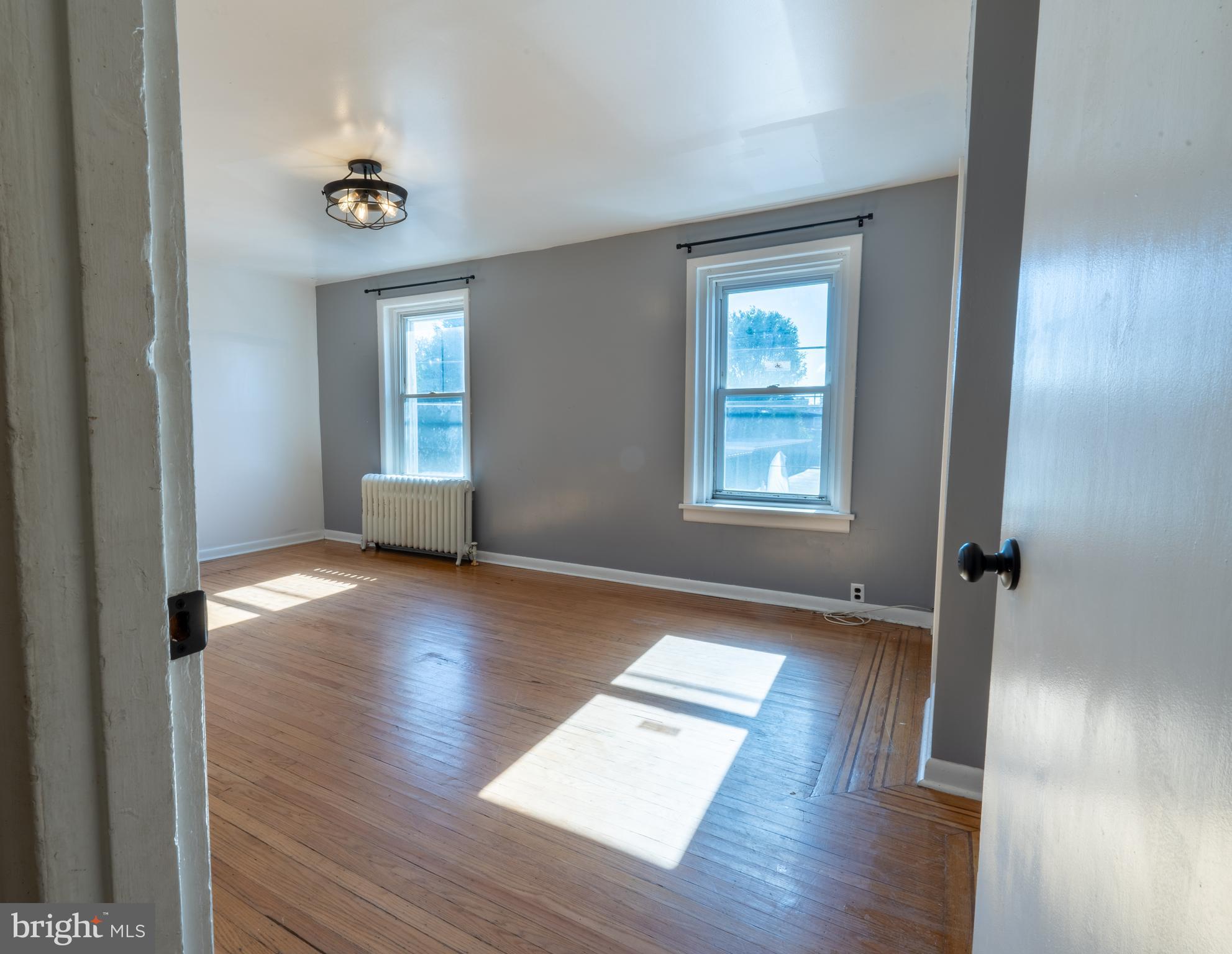 3618 Emerald Street Philadelphia, PA 19134 - Photo 15 of 34 an empty room with wooden floor and windows