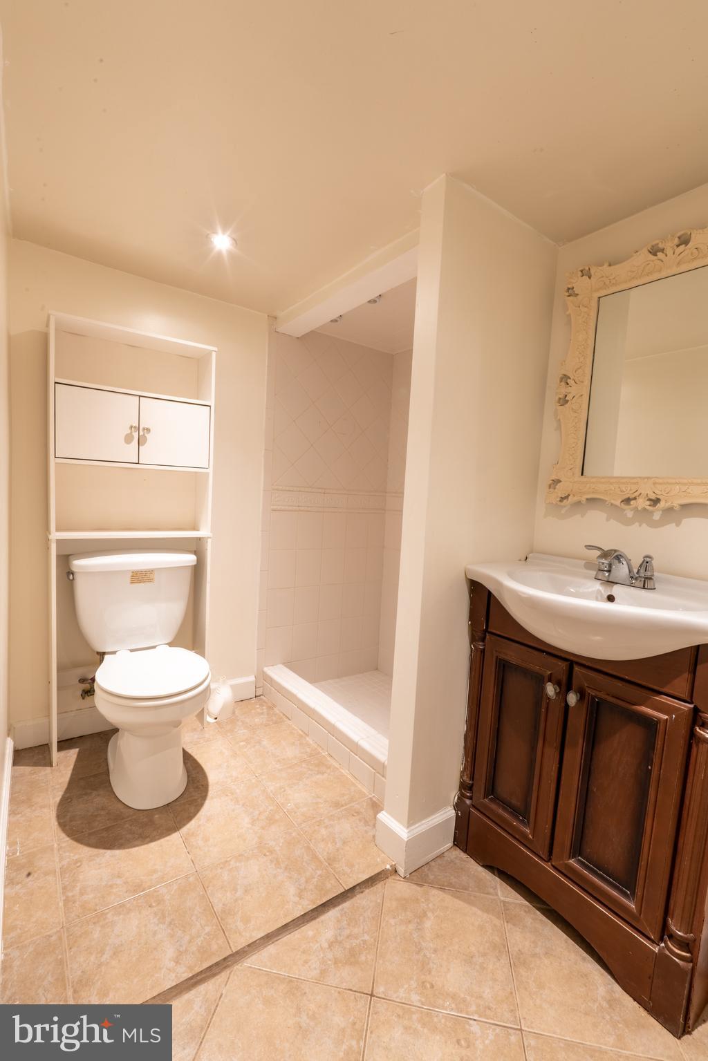 3618 Emerald Street Philadelphia, PA 19134 - Photo 17 of 34 a bathroom with a sink a toilet and a mirror
