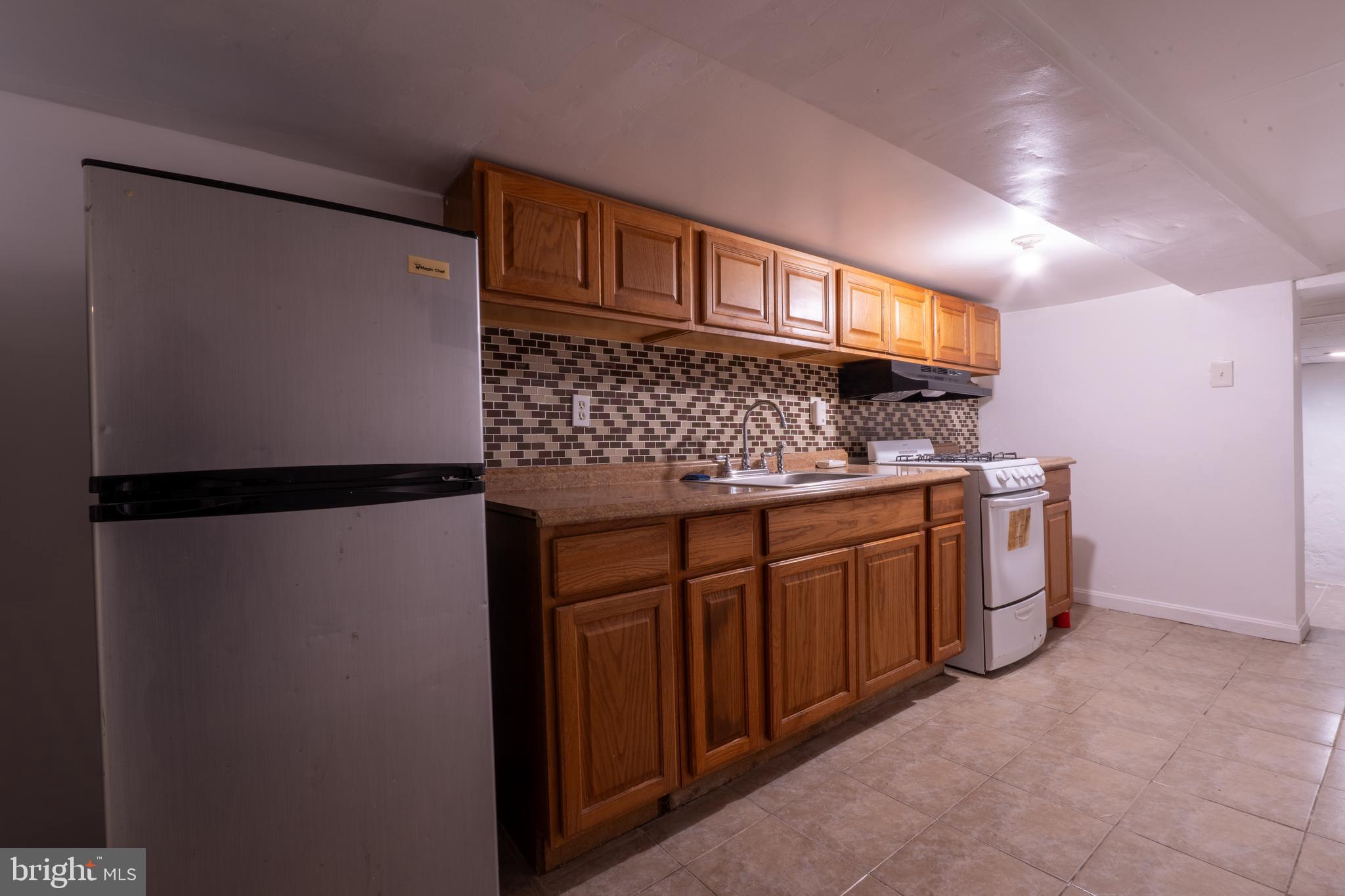 3618 Emerald Street Philadelphia, PA 19134 - Photo 24 of 34 a kitchen with stainless steel appliances granite countertop a refrigerator and a sink