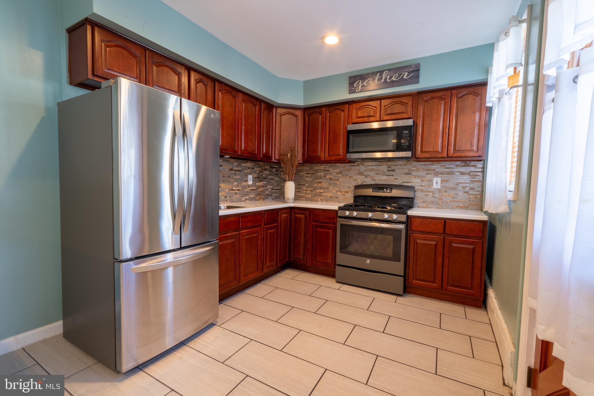 3618 Emerald Street Philadelphia, PA 19134 - Photo 26 of 34 a kitchen with granite countertop a refrigerator stove and microwave