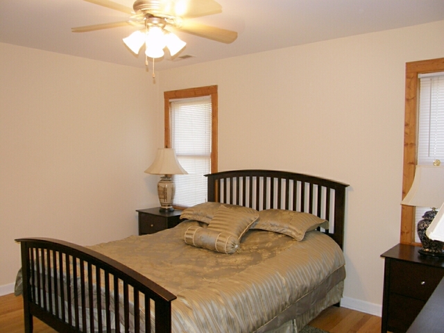130 Bay Road Fox Lake, IL 60020 - Photo 16 of 21 a bedroom with a bed and a chandelier