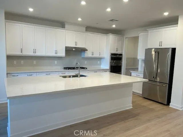 an empty room with wooden floor fireplace and windows