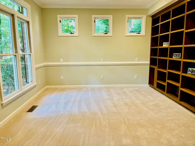 a view of an empty room with a fireplace and a window