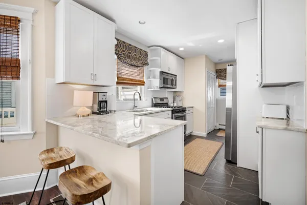 a kitchen with stainless steel appliances granite countertop a sink and a refrigerator