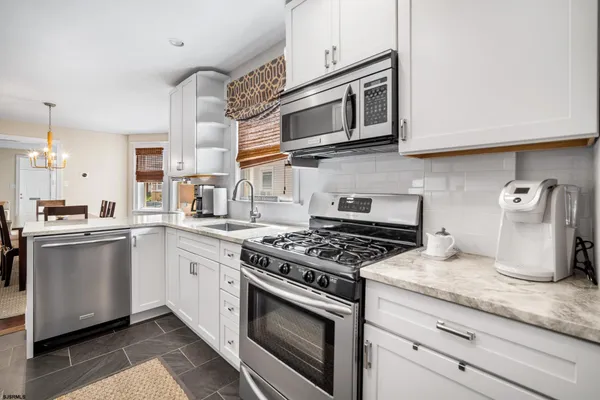 a kitchen with granite countertop stainless steel appliances and white cabinets