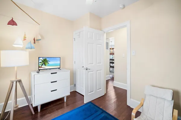 a view of a hallway with wooden floor and cabinet