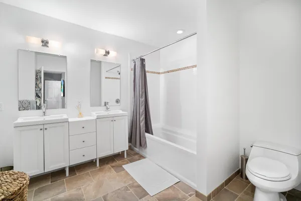 a bathroom with a double vanity sink toilet and shower