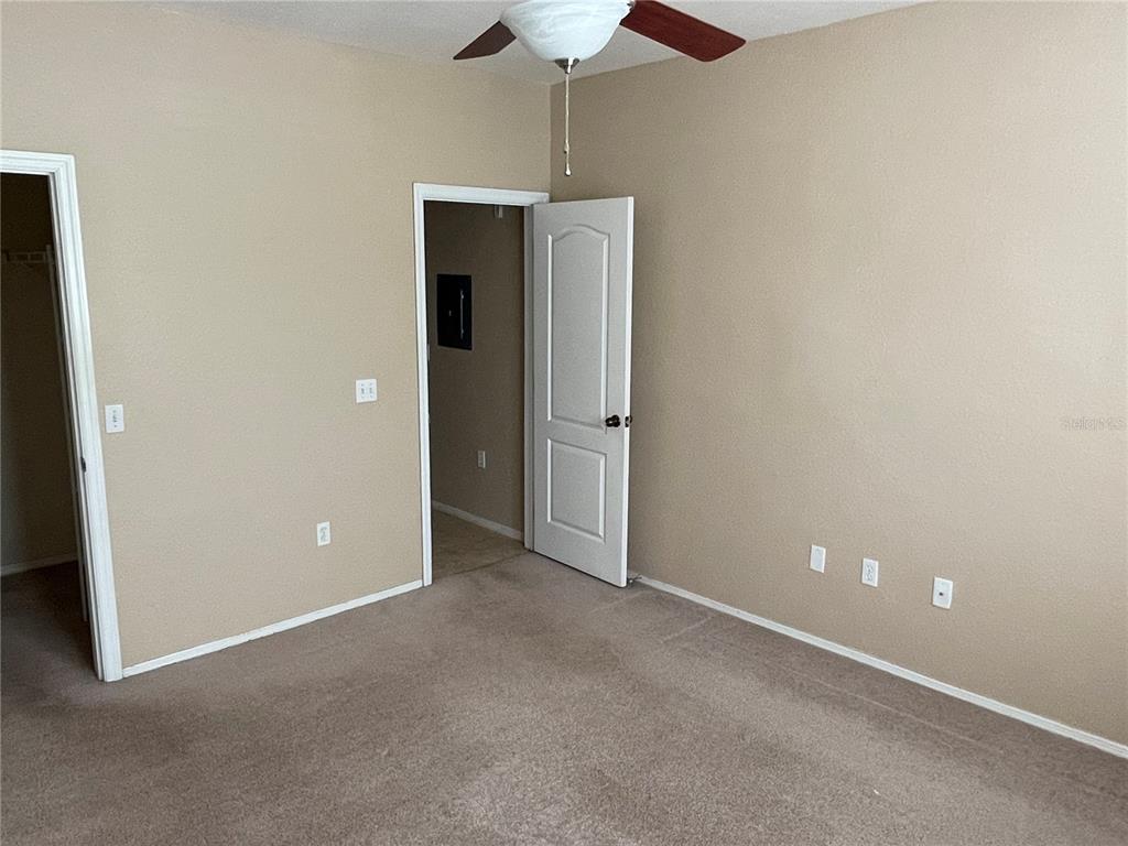 3355 South Kirkman Road, Unit 1324 Orlando, FL 32811 - Photo 11 of 19 an empty room with a hallway and a chandelier fan