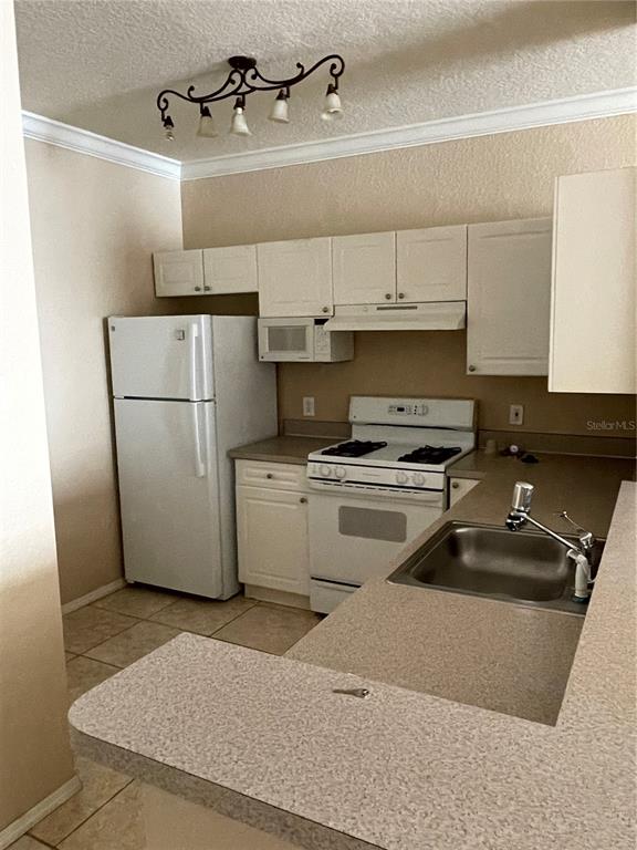 3355 South Kirkman Road, Unit 1324 Orlando, FL 32811 - Photo 6 of 19 a kitchen with a refrigerator sink and cabinets