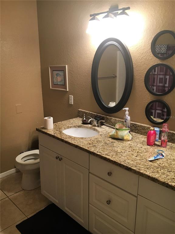 3355 South Kirkman Road, Unit 1324 Orlando, FL 32811 - Photo 9 of 19 a bathroom with a toilet a sink and a mirror