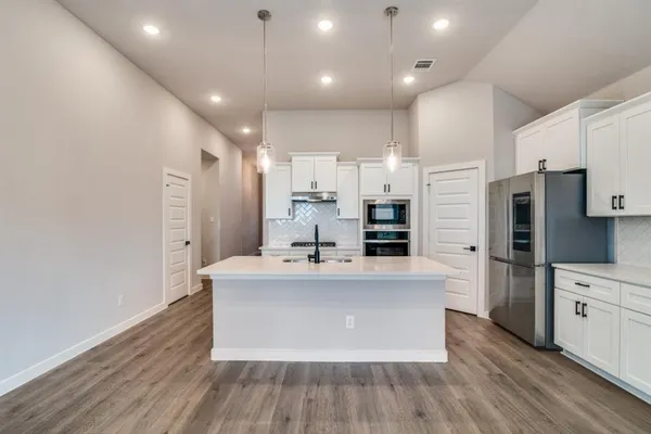 a kitchen with sink and white cabinets