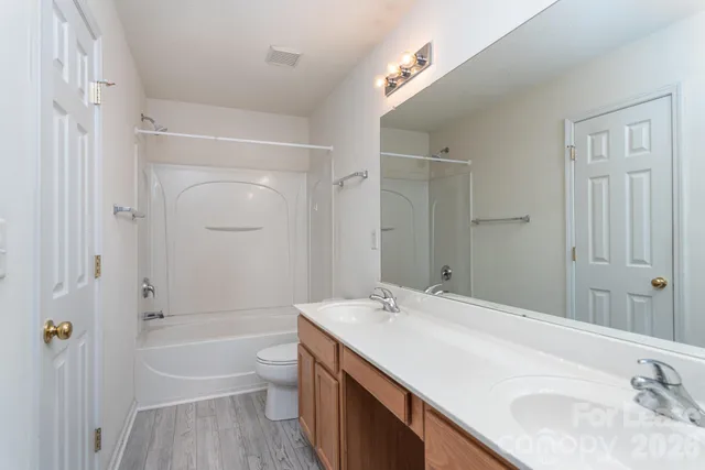 a bathroom with a granite countertop sink a toilet and shower