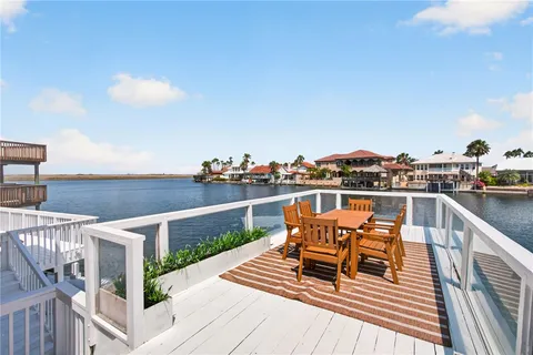 a roof deck with table and chairs a barbeque with wooden floor and fence