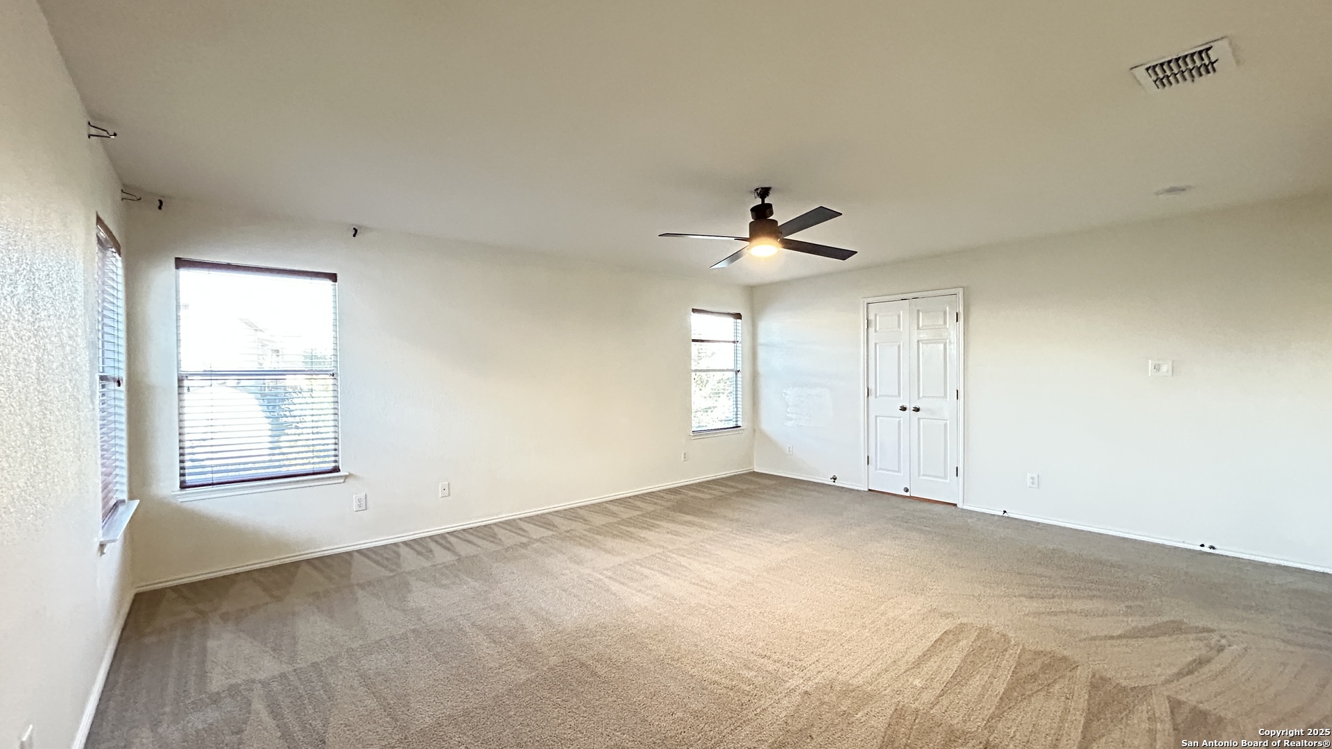 11015 Mustang Spring San Antonio, TX 78254 - Photo 14 of 29 an empty room with windows and chandelier fan