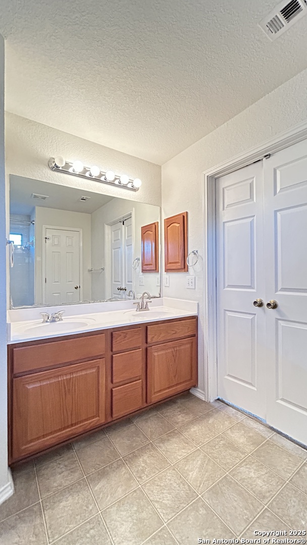 11015 Mustang Spring San Antonio, TX 78254 - Photo 16 of 29 a spacious bathroom with a vanity a mirror and a bathtub