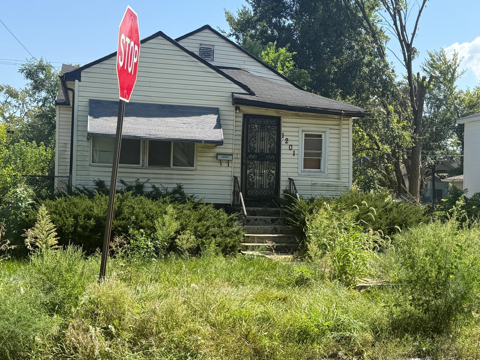 1201 Rutledge Street Gary, IN 46404 - Photo 3 of 6 a backyard of a house with plants and large tree